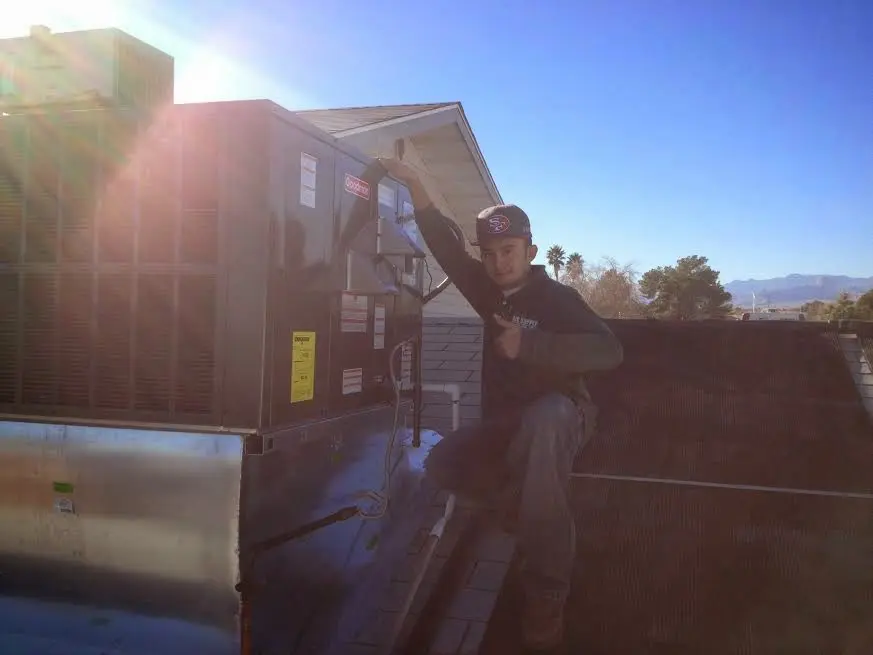 HVAC technician performing Air Duct Cleaning on a rooftop unit in Gardere